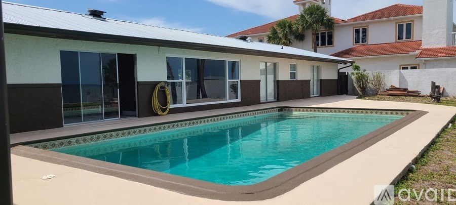 A swimming pool in front of a house.