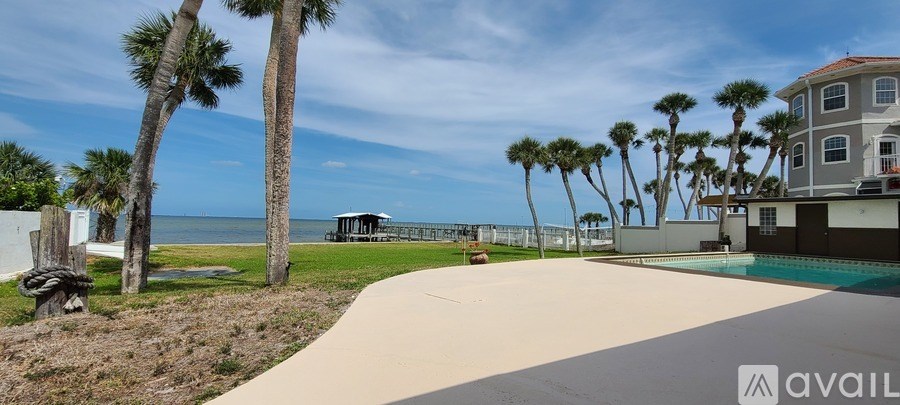A beach house with a pool and palm trees in the background.
