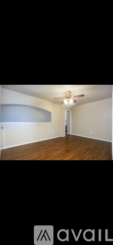 A room with wooden flooring and a ceiling fan.