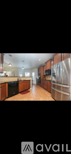 A kitchen with wooden cabinets and a black dishwasher.