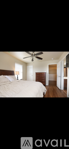 A bedroom with a large bed and a ceiling fan.