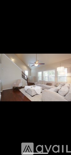 A living room with a white couch and a ceiling fan.