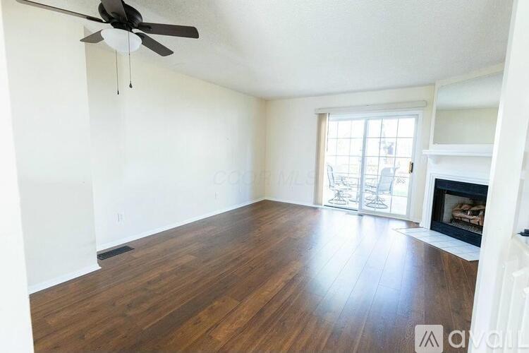 A room with a wood floor and a ceiling fan.