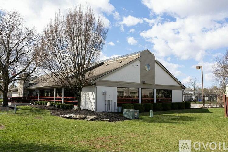 A white building with a grey roof and a sign that says "available" in front of it.