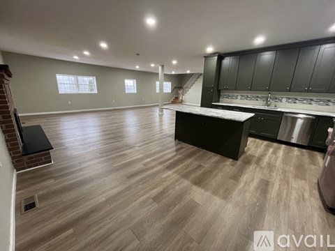 A spacious kitchen with dark wood cabinets and a stainless steel dishwasher.