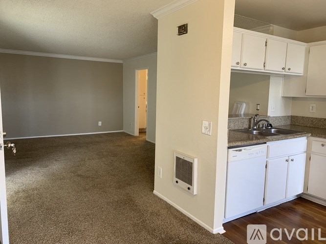 A kitchen area with white cabinets and a sink.