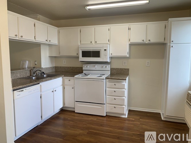 A kitchen with white cabinets and appliances.