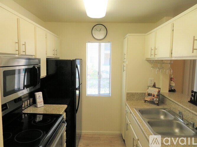 A kitchen with black appliances and white cabinets.