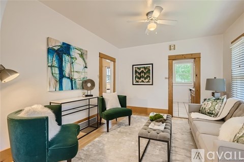 A living room with a green chair and a painting on the wall.