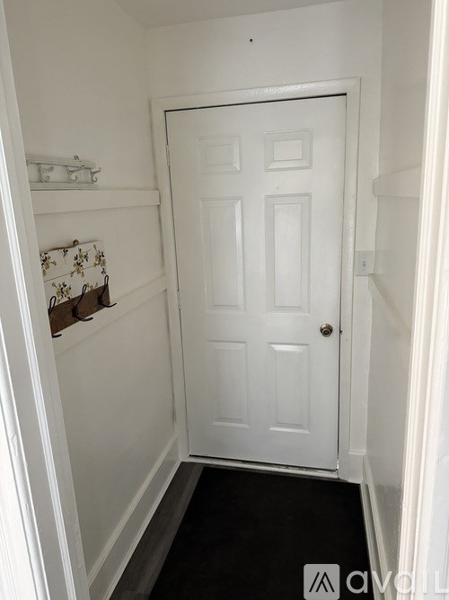 A white door is in a small hallway.