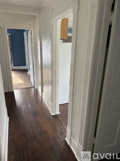 A hallway with white doors and wood floors.