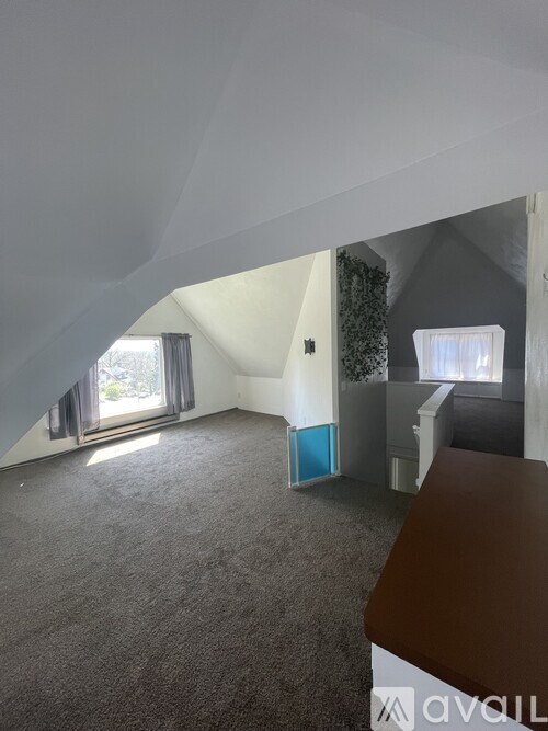 A room with a carpeted floor and a window with curtains.