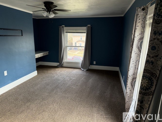 A room with blue walls and a ceiling fan.