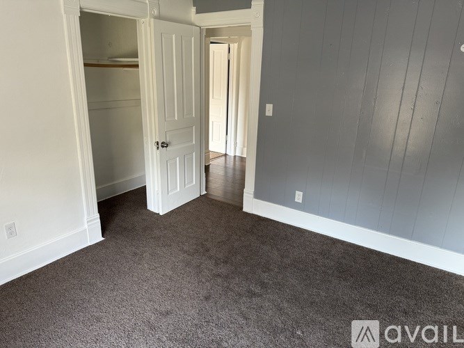 A room with a carpeted floor and a white door.