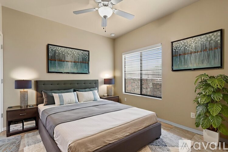 A bedroom with a large bed and two framed pictures on the wall.
