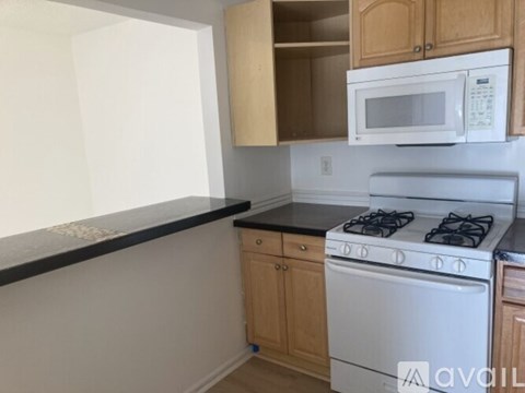 A kitchen with a white oven and black countertops.