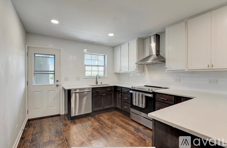A modern kitchen with a glass table and stainless steel appliances.