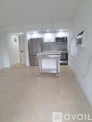 A kitchen with a stainless steel refrigerator, microwave, and oven.
