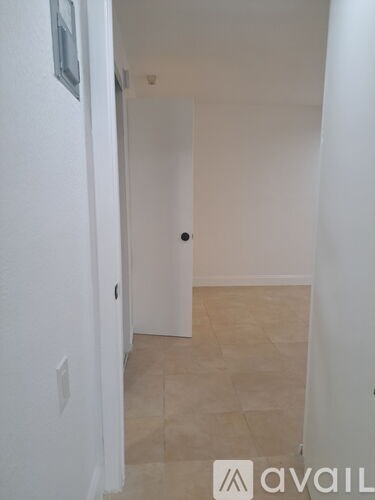 A hallway with a door and tiled floor.