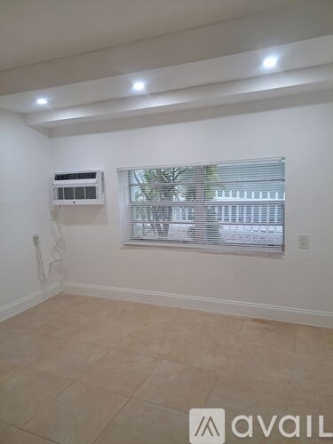 A room with a window and a wall-mounted air conditioner unit.