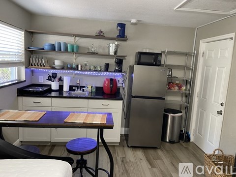 A kitchen with a table and chairs in front of a refrigerator.
