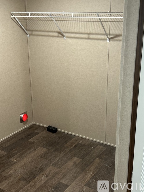 A room with a red light and a black bag on the floor.