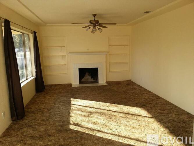 A living room with a fireplace and a ceiling fan.