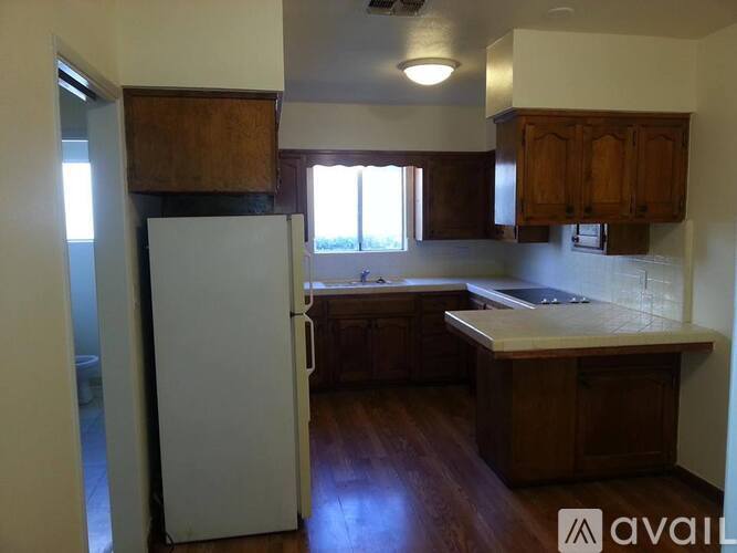 A kitchen with wooden cabinets and a white refrigerator.