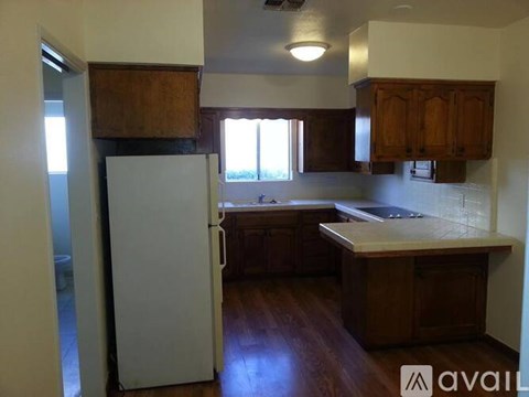 A kitchen with wooden cabinets and a white refrigerator.