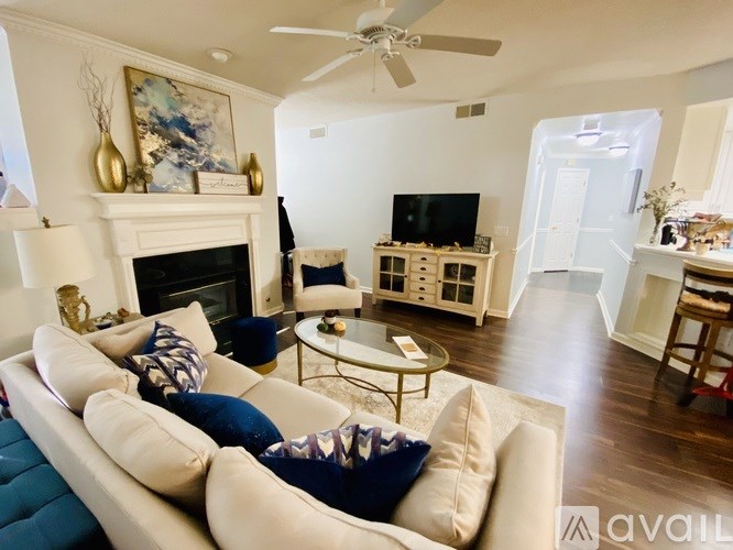 A living room with a white couch and a fireplace.