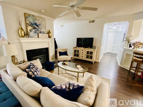 A living room with a white couch and a fireplace.