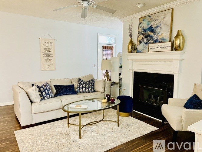 A living room with a white couch, a coffee table, and a fireplace.