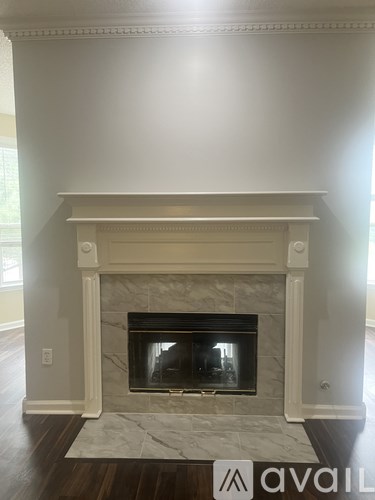 A fireplace with a white mantle and a stone surround.