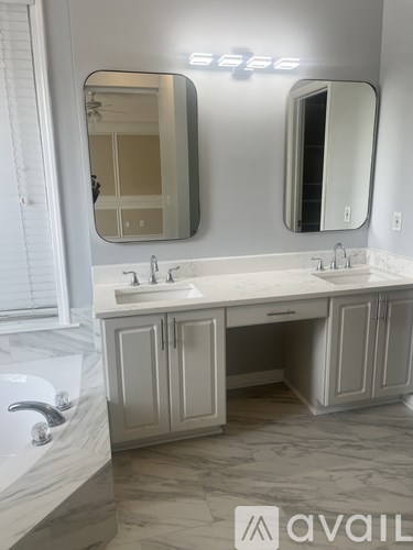 A bathroom with a double sink vanity and a large mirror above it.