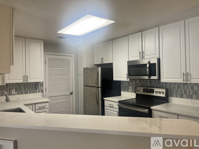 A kitchen with white cabinets and a black stove top oven.