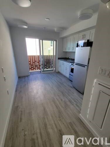 A kitchen with white cabinets and a white fridge.