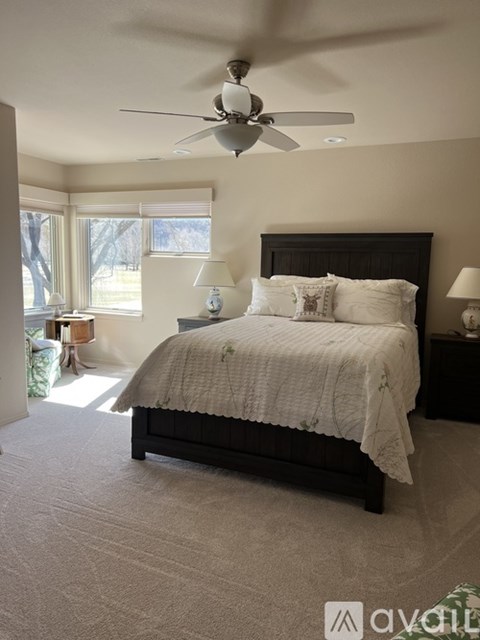 A bedroom with a large bed and a ceiling fan.