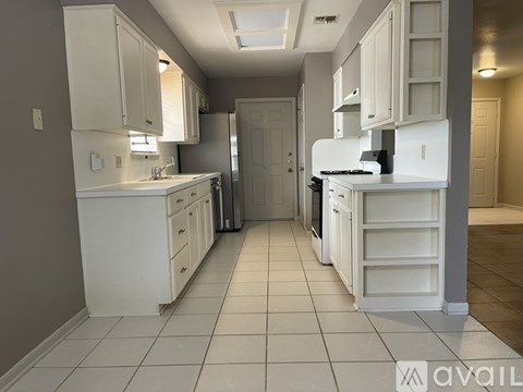 A kitchen with white cabinets and appliances.