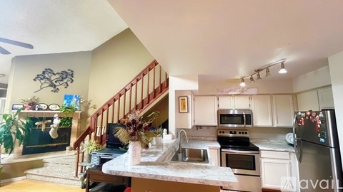 A kitchen with a staircase and a dining table.
