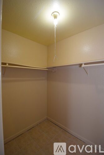 A small, empty room with a single light bulb hanging from the ceiling.