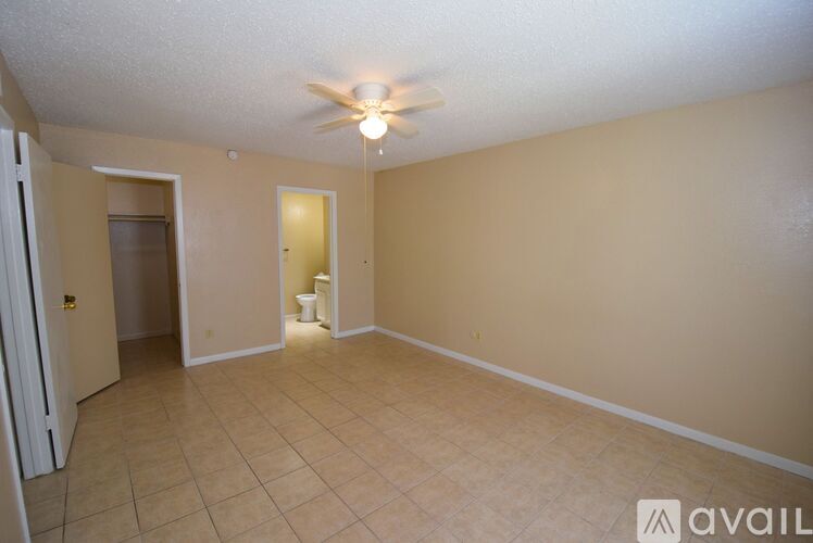 A room with a ceiling fan and tile flooring.