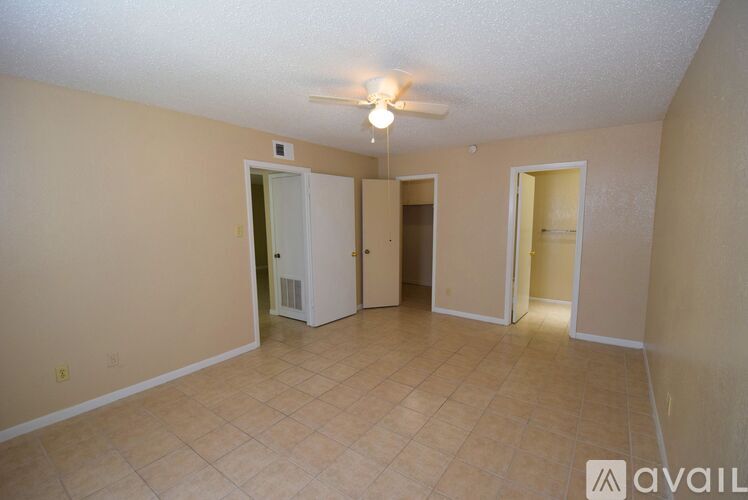 A room with a ceiling fan and tile flooring.