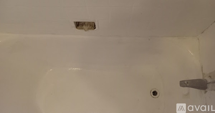 A white bathroom with a hole in the wall.