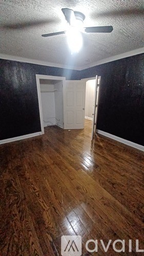 A room with a ceiling fan and a door.