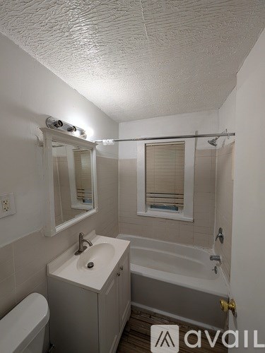 A hallway with a white door and a vacuum cleaner in the background.