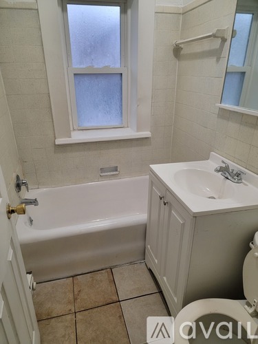 A kitchen with a white refrigerator, black stove, and a sink.