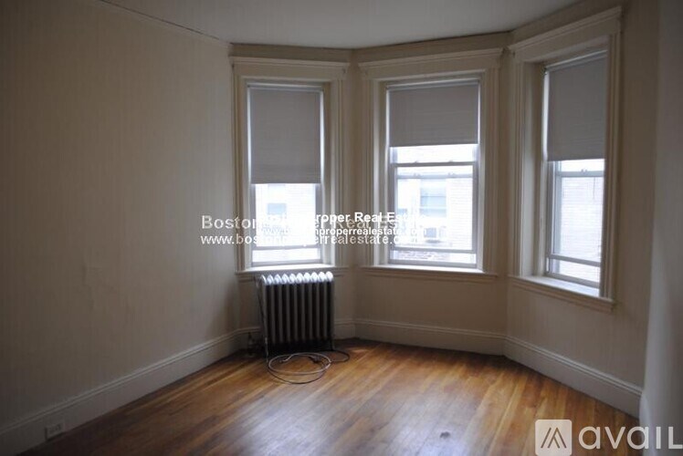 A room with wooden floors and two windows.