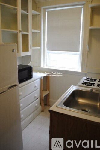 A kitchen with a sink, stove and refrigerator.