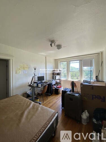 A room with a bed, a desk, and a window.