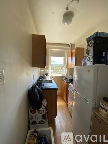 A kitchen with a refrigerator, sink, and cabinets.